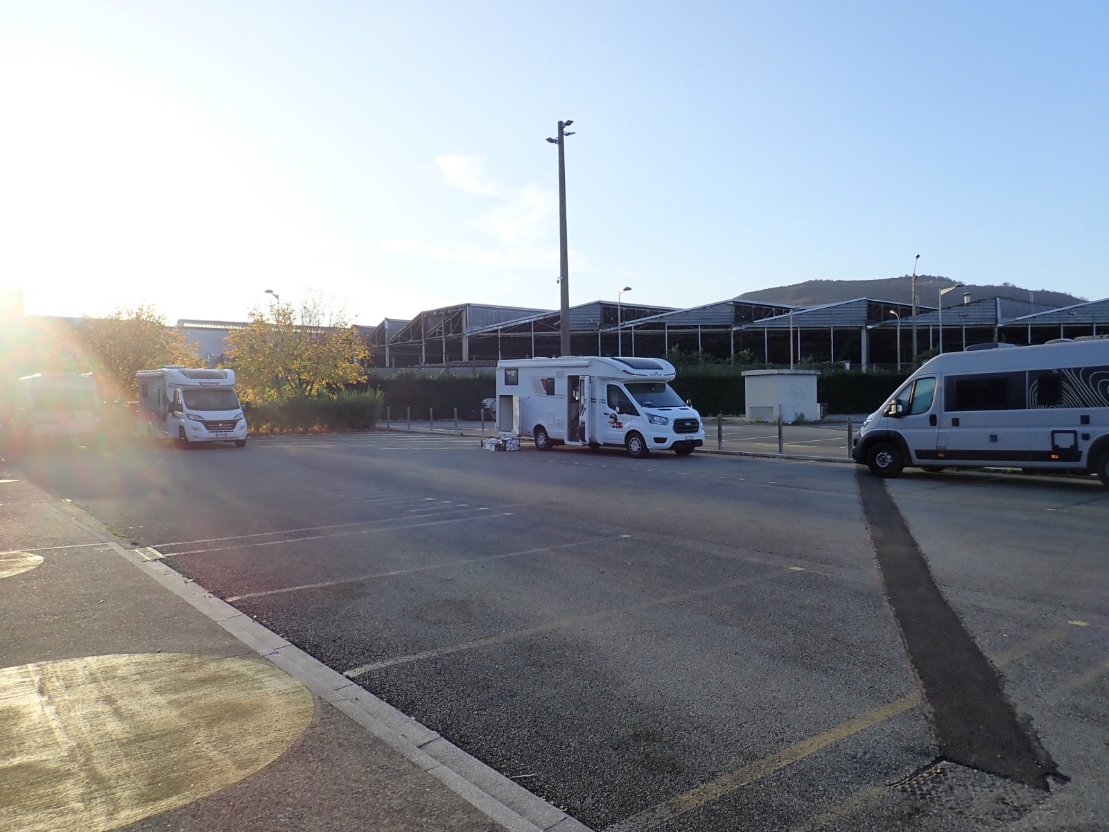Autocaravanas aparcadas en un área de servicio al amanecer