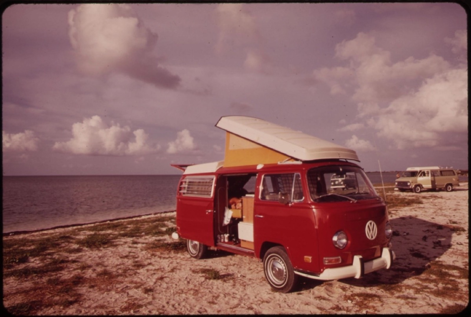 Furgoneta camper clásica de color rojo aparcada en una playa